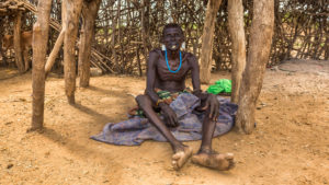 43485573 - omo valley, ethiopia - may 6, 2015 : old warrior from the african tribe daasanach relaxing in his village.